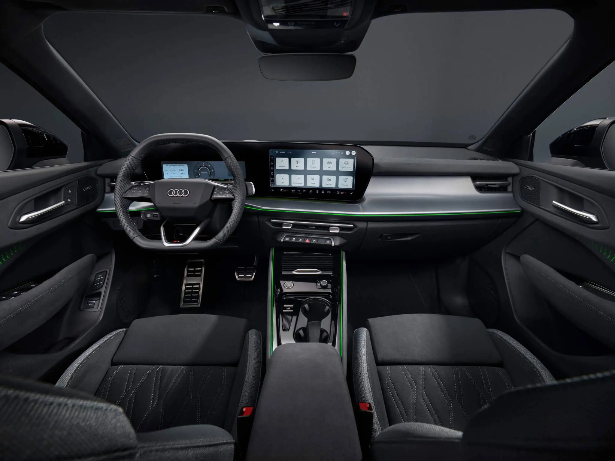 Interior do Audi Q3 2026 – cockpit moderno com volante desportivo, painel digital, ecrã tátil e iluminação ambiente verde.