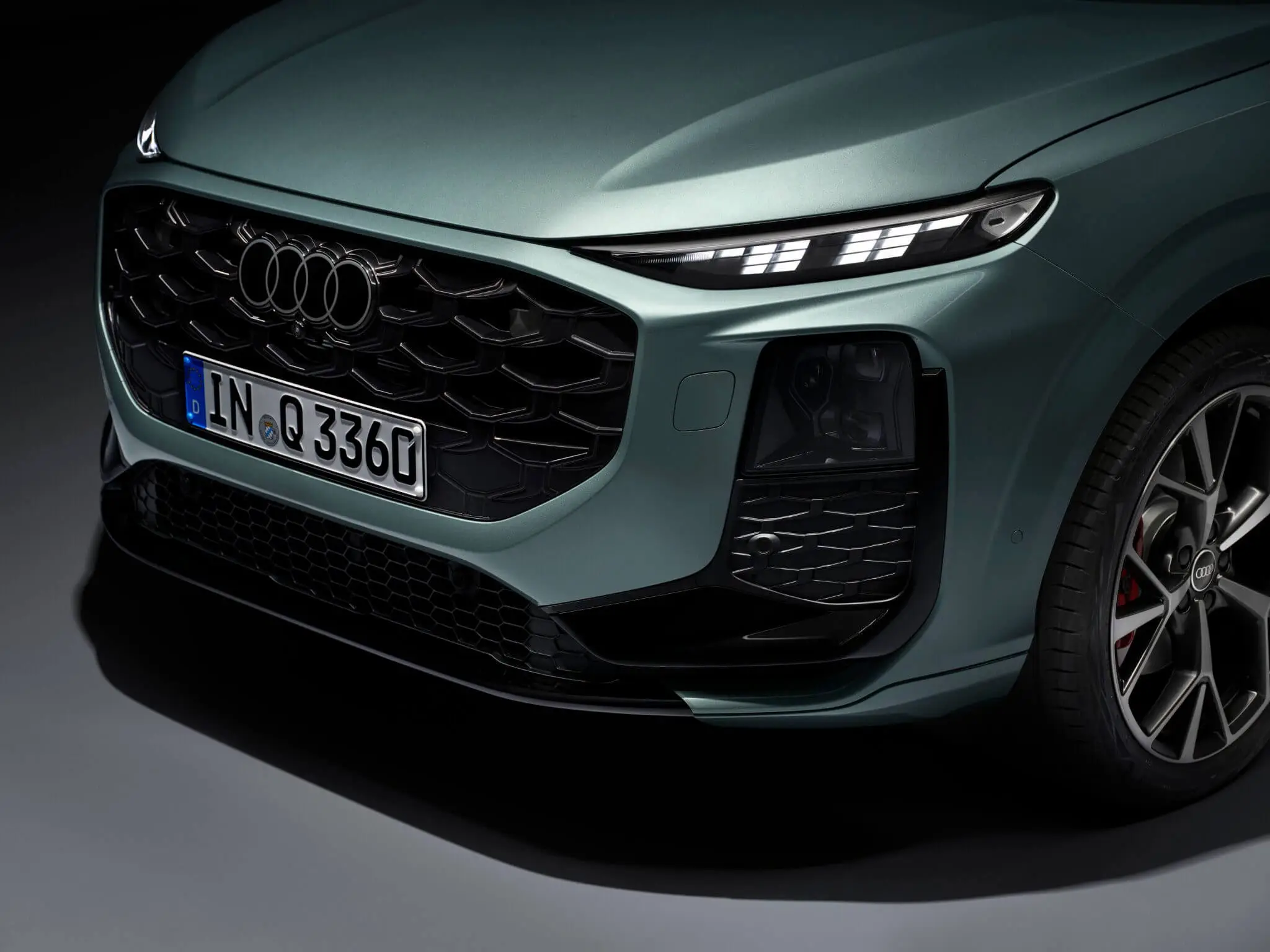 “Detalhe da frente do SUV Audi Q3 2026 — grelha Singleframe, faróis LED e para-choques desportivo com jante dianteira.