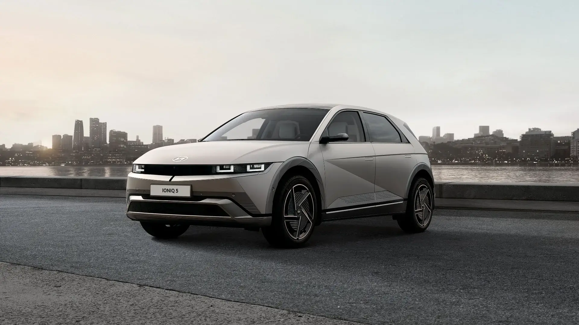 IONIQ-5 visto de frente com paisagem citadina por trás