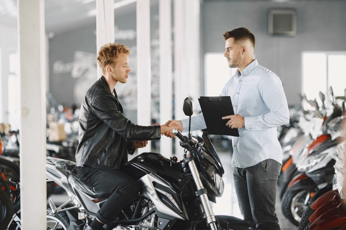 homem a comprar motos usadas num stand