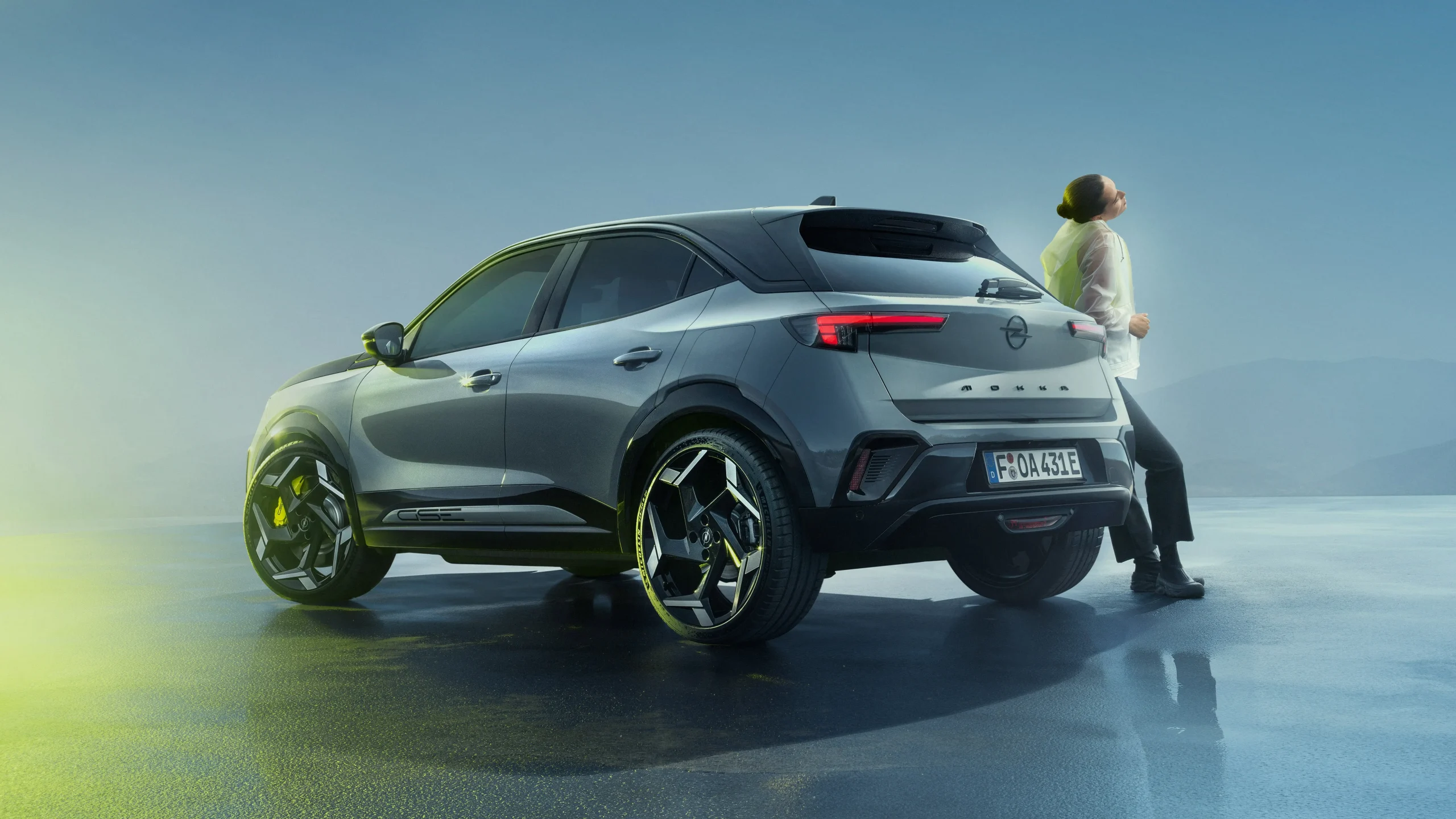 Opel Mokka GSE visto de trás com mulher encostada ao carro